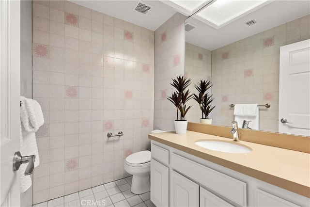 bathroom featuring visible vents, tile walls, and tile patterned floors