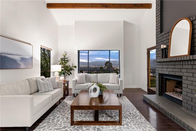 living area with high vaulted ceiling, dark wood-style flooring, a fireplace, a healthy amount of sunlight, and beam ceiling