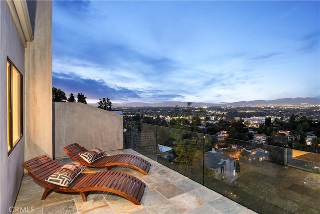 balcony at dusk featuring a mountain view