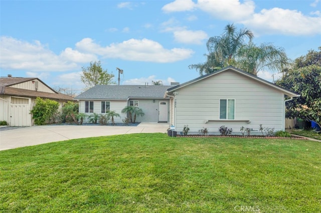 ranch-style home with concrete driveway and a front lawn