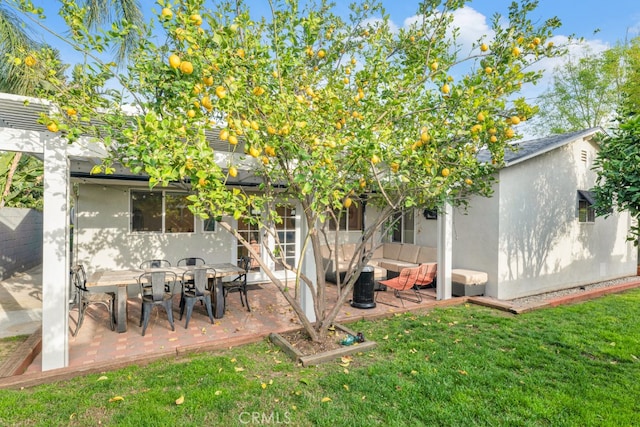 rear view of property with stucco siding, a yard, outdoor lounge area, and a patio