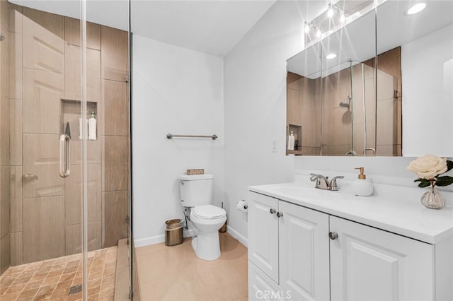 bathroom featuring toilet, a shower stall, baseboards, and vanity