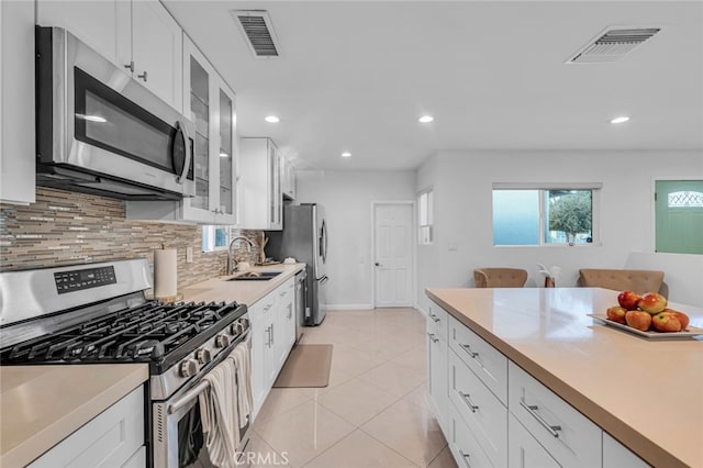 kitchen featuring appliances with stainless steel finishes, light countertops, visible vents, and a sink