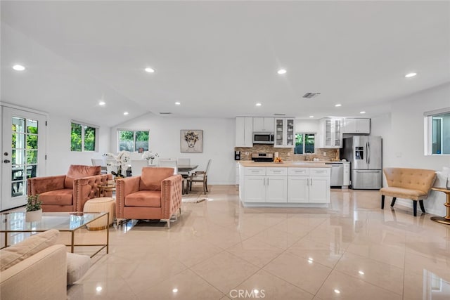 living room with recessed lighting, visible vents, vaulted ceiling, and baseboards