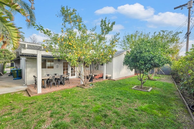 view of yard featuring french doors, fence, and a patio