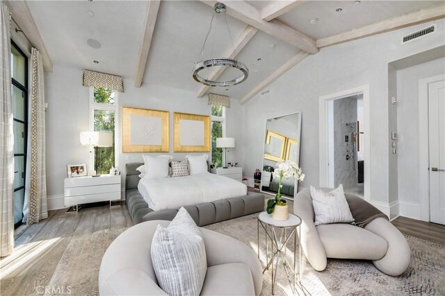 bedroom featuring visible vents, vaulted ceiling with beams, baseboards, and wood finished floors