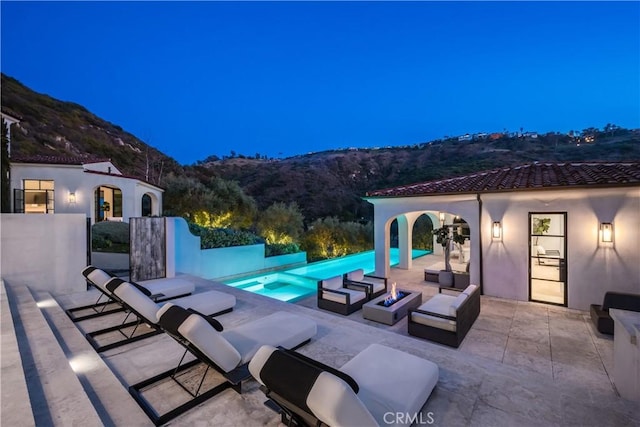 view of patio featuring an outdoor fire pit and a mountain view