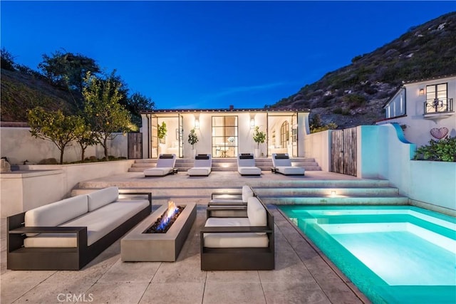 view of pool featuring a patio, an outdoor living space with a fire pit, fence, an exterior structure, and an outdoor structure