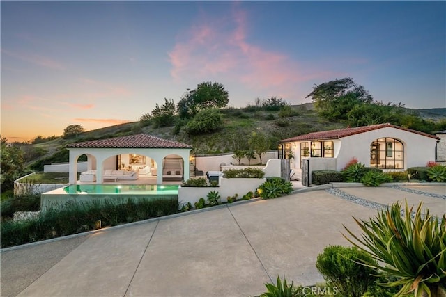 mediterranean / spanish house with a patio, fence, a gazebo, a tiled roof, and stucco siding