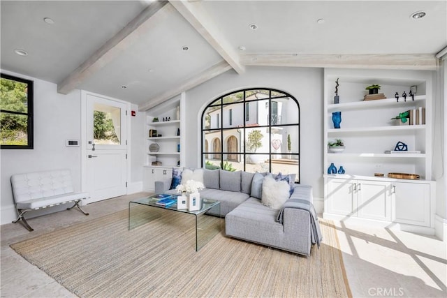 living room featuring built in features, a wealth of natural light, lofted ceiling with beams, and baseboards