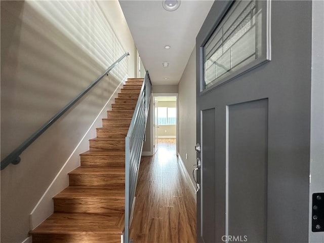 stairway with baseboards and wood finished floors