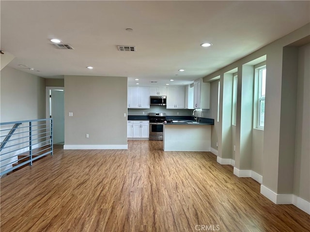 kitchen featuring dark countertops, visible vents, appliances with stainless steel finishes, and open floor plan