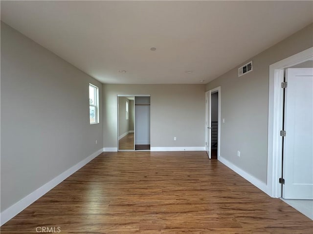 interior space with visible vents, baseboards, a closet, and wood finished floors