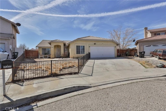 mediterranean / spanish-style home featuring a garage, concrete driveway, a fenced front yard, and stucco siding