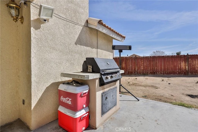 view of patio / terrace featuring fence and a grill