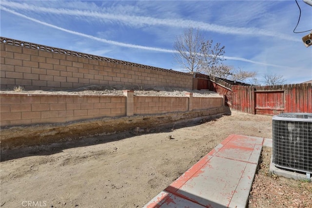 view of yard with a fenced backyard and central AC unit