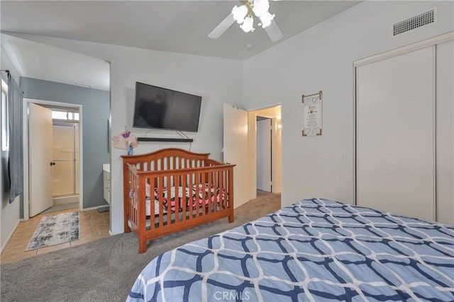 bedroom featuring visible vents, ceiling fan, vaulted ceiling, carpet flooring, and a closet