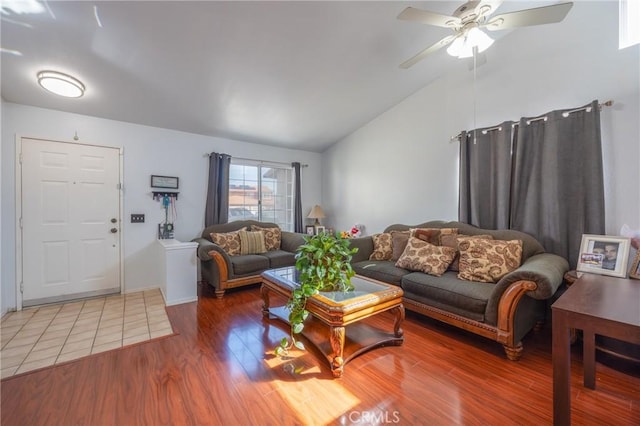 living area with a ceiling fan, vaulted ceiling, and wood finished floors