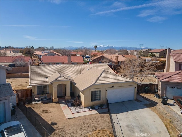 view of front of house with a residential view, a tile roof, driveway, and fence