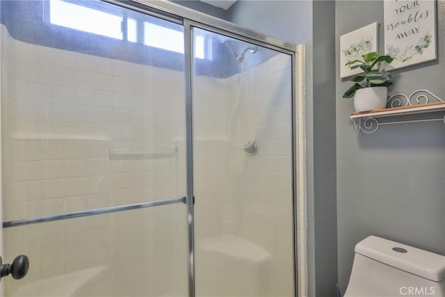 full bathroom featuring toilet and a tile shower