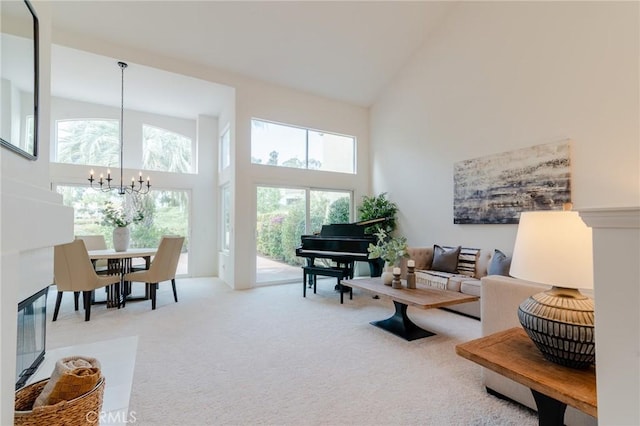 living area featuring carpet floors, high vaulted ceiling, and a notable chandelier