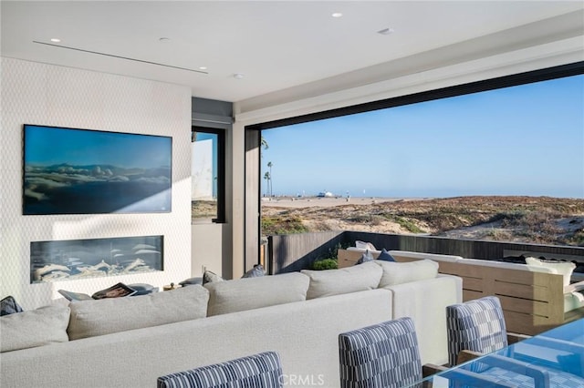 living area featuring recessed lighting and a glass covered fireplace