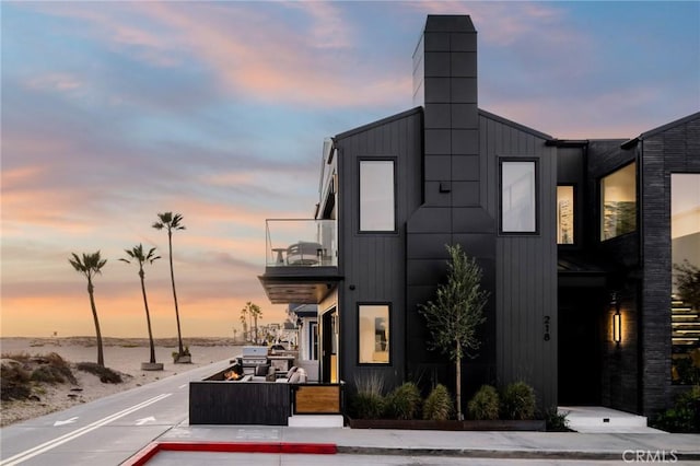 property at dusk featuring a water view