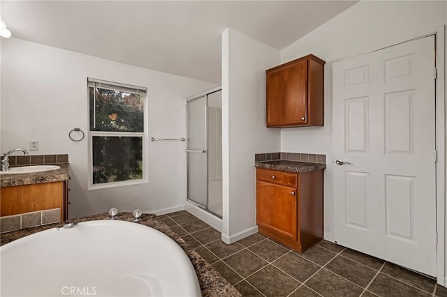bathroom featuring tile patterned flooring, a washtub, a stall shower, and vanity