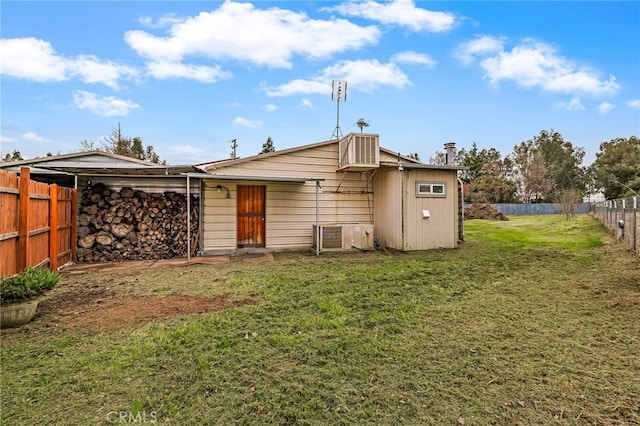 back of property with fence and a lawn