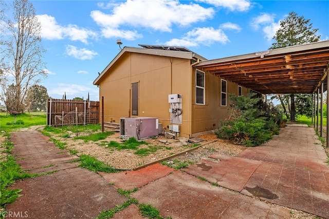 view of side of home with fence and ac unit