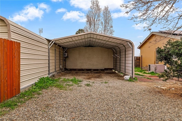 view of car parking with a detached carport, driveway, and fence