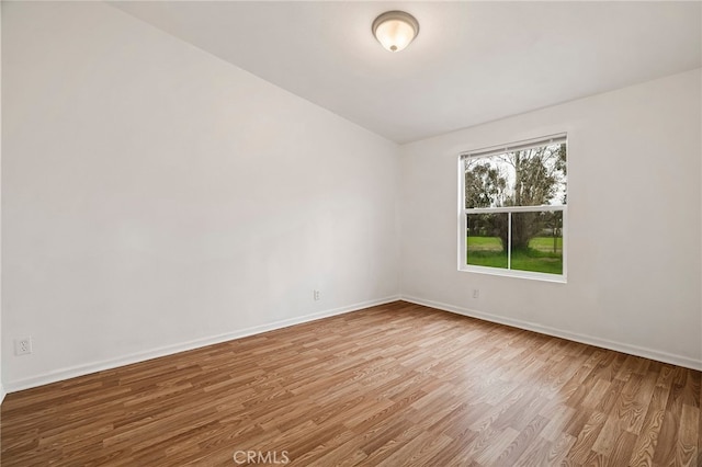 empty room featuring baseboards and wood finished floors