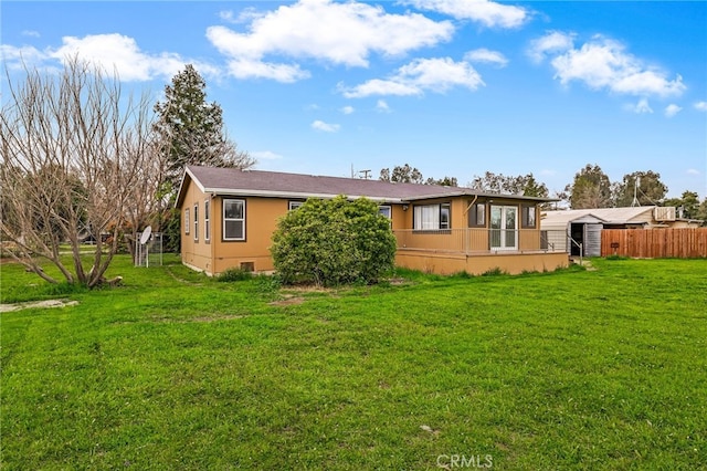 rear view of property with fence and a yard