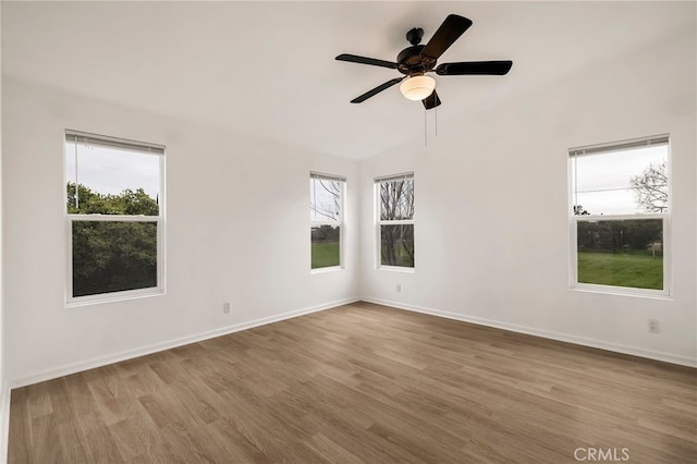 spare room featuring baseboards, wood finished floors, and a ceiling fan