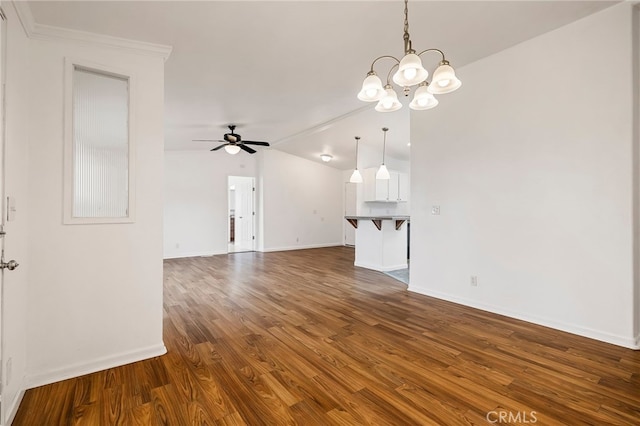 unfurnished living room with dark wood-type flooring, baseboards, vaulted ceiling, and ceiling fan with notable chandelier