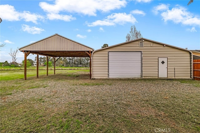 detached garage with driveway and a carport