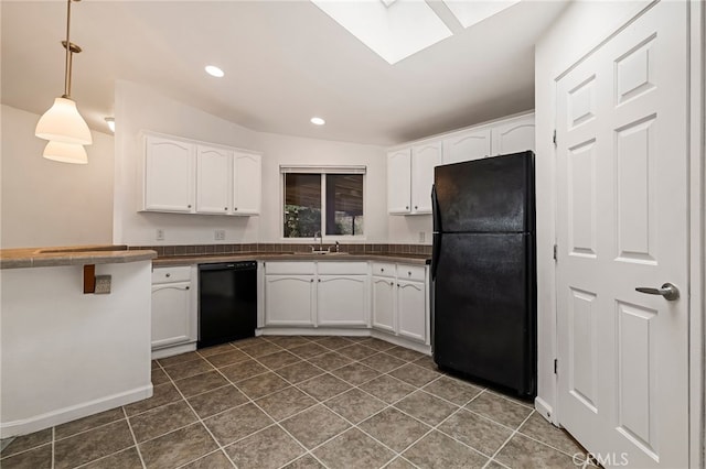 kitchen featuring white cabinets, dark countertops, decorative light fixtures, and black appliances