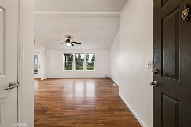 interior space with a ceiling fan, dark wood-style floors, and baseboards