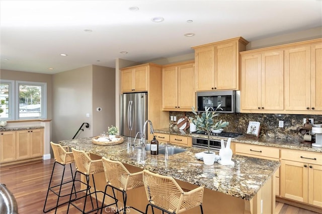 kitchen with a sink, appliances with stainless steel finishes, and light brown cabinetry