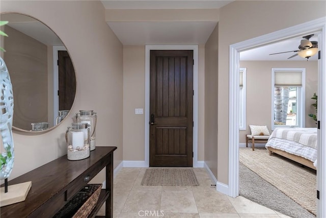 entrance foyer featuring light tile patterned floors, baseboards, and a ceiling fan