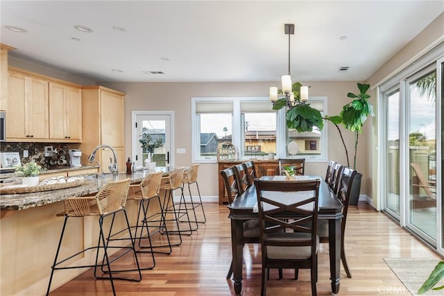 dining space with plenty of natural light, light wood-style flooring, and visible vents