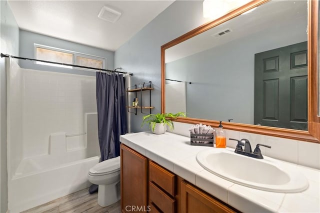 bathroom with toilet, shower / tub combo, wood finished floors, visible vents, and vanity