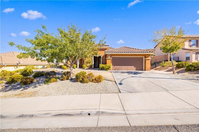 view of front of house with concrete driveway, a tiled roof, an attached garage, and stucco siding