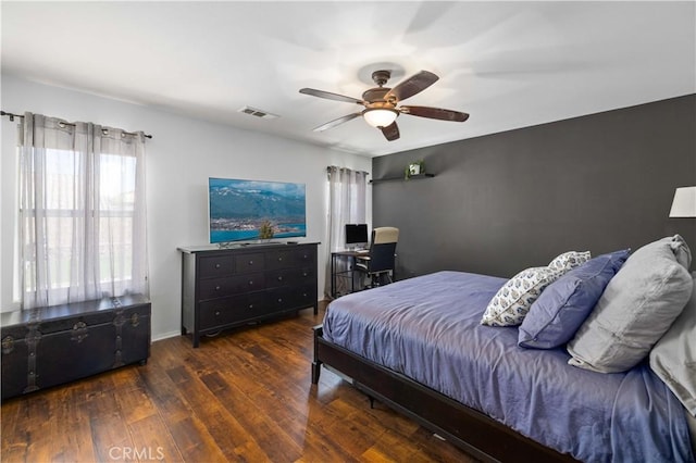 bedroom with ceiling fan, wood finished floors, and visible vents