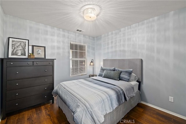 bedroom with baseboards, visible vents, and dark wood-style flooring