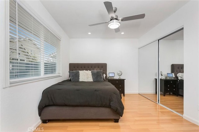 bedroom with light wood finished floors, baseboards, recessed lighting, a closet, and a ceiling fan