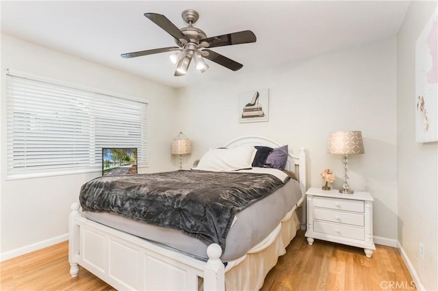 bedroom featuring baseboards, light wood-style floors, and a ceiling fan