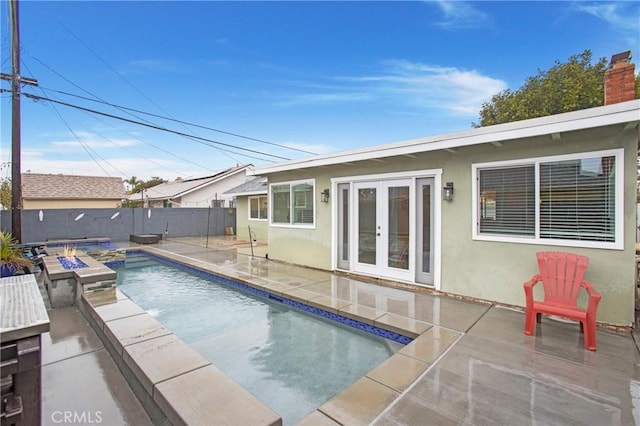 view of pool with a patio, french doors, a fenced in pool, and a fenced backyard