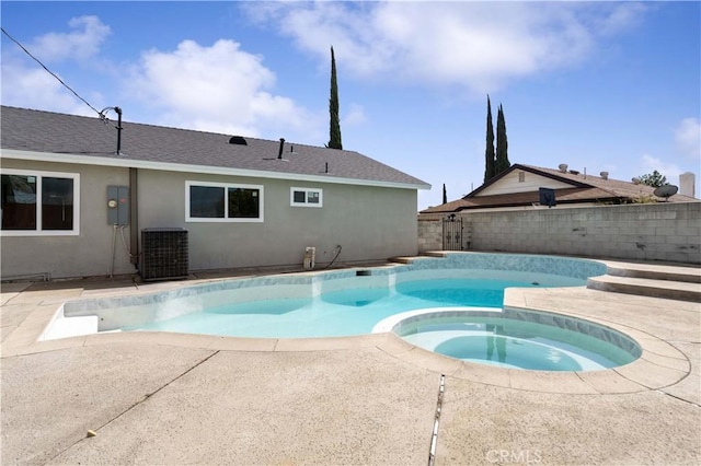 view of swimming pool featuring a patio, fence, a pool with connected hot tub, and central air condition unit