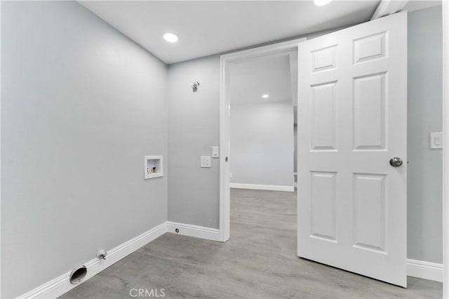 clothes washing area featuring laundry area, light wood finished floors, hookup for a washing machine, and baseboards